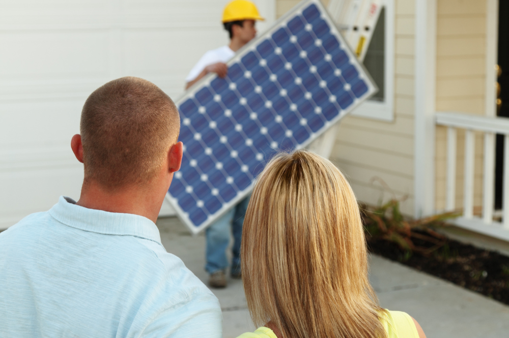 Image of a man and woman watching a solar panel being installed