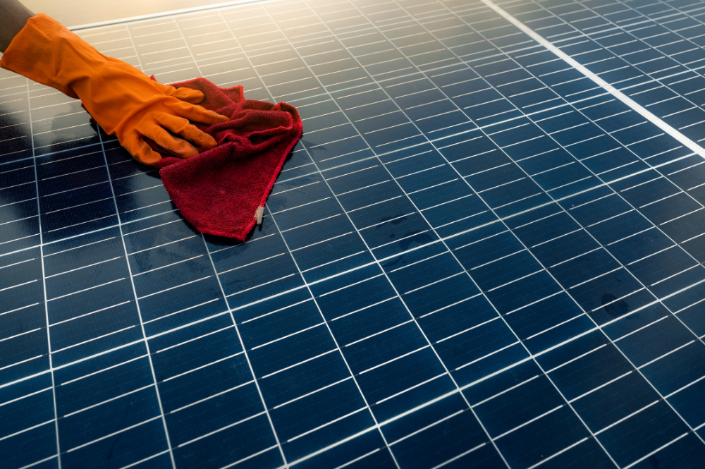 Image of a person cleaning a solar panel.